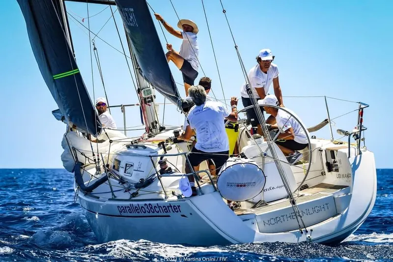  Yacht Photos Pics Sailing crew on 2004 Dufour 34 Performance yacht navigating blue waters.