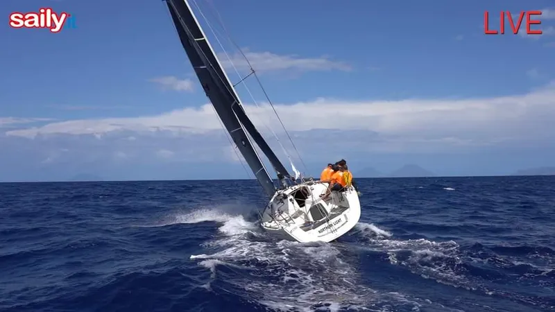  Yacht Photos Pics Sailboat Dufour 34 Performance 2004 navigating ocean waves under clear blue sky.
