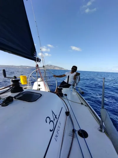 Yacht Photos Pics Man relaxing on a 2004 Dufour 34 Performance sailboat at sea.
