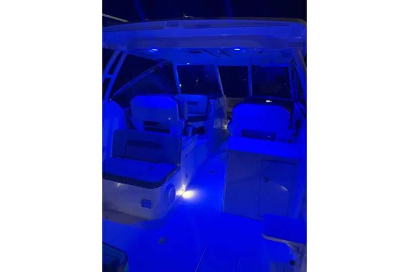 Perfect Draw Yacht Photos Pics 2020 Pursit DC 325 boat interior illuminated with blue LED lighting.