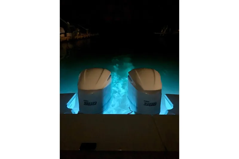 Perfect Draw Yacht Photos Pics Twin 300 horsepower engines on a 2020 Pursit DC 325 boat, illuminated at night.