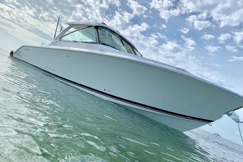 Perfect Draw Yacht Photos Pics 2020 Pursit DC 325 boat on clear water under a partly cloudy sky.