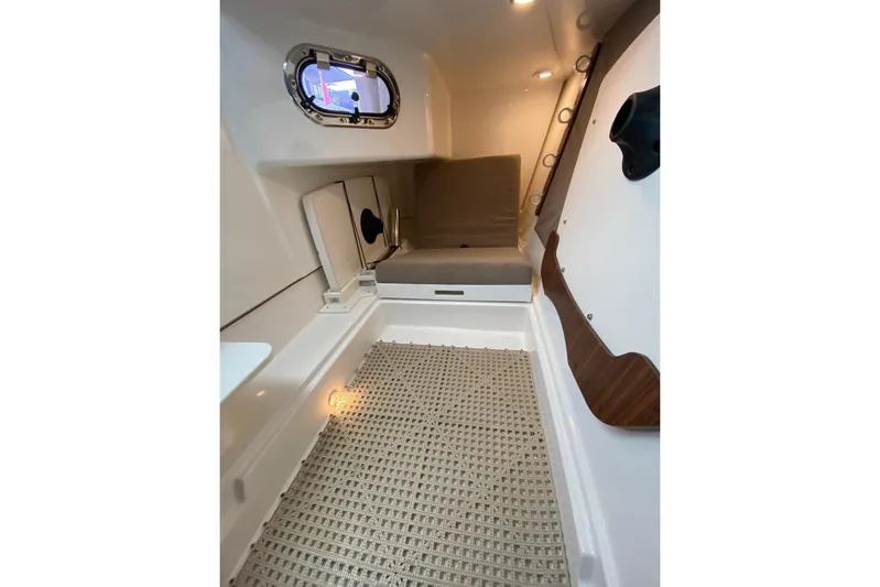 Perfect Draw Yacht Photos Pics 2020 Pursit DC 325 cabin interior with cushioned seating and porthole window.