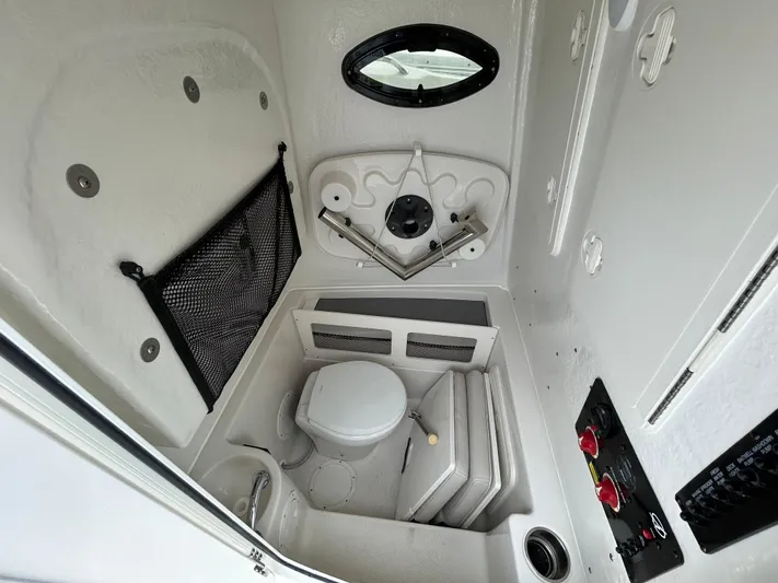  Yacht Photos Pics 2024 Sailfish 242CC boat interior cabin with toilet and storage compartments.