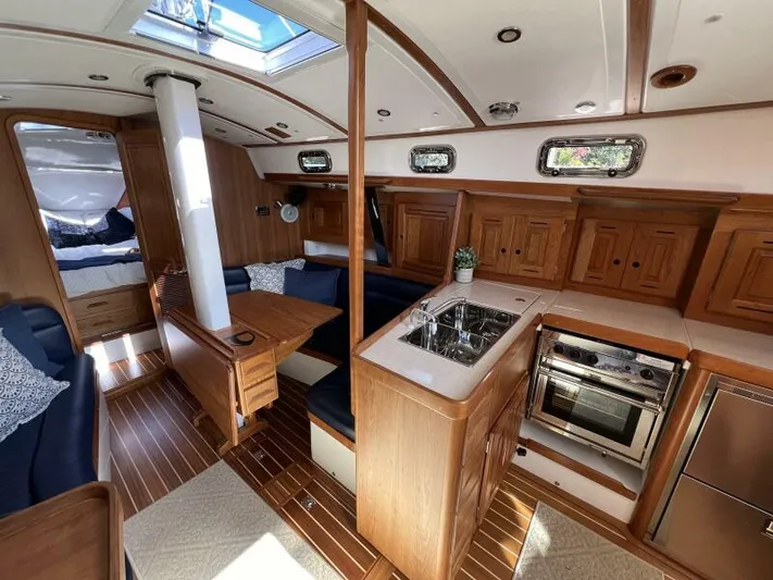 #14 Yacht Photos Pics Luxurious 2024 Tartan 395 yacht interior with wood finish, kitchen, and seating area.