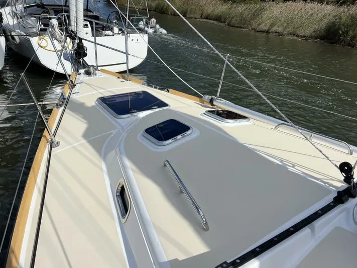 #14 Yacht Photos Pics 2024 Tartan 395 sailboat deck with hatches, docked beside another boat.