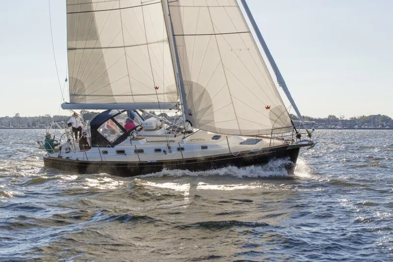 #14 Yacht Photos Pics 2024 Tartan 395 sailboat navigating on open water with full sails.