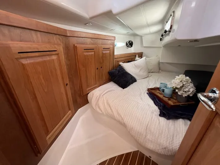 #14 Yacht Photos Pics Luxurious cabin interior of 2024 Tartan 395 yacht with cozy bedding and wooden cabinetry.