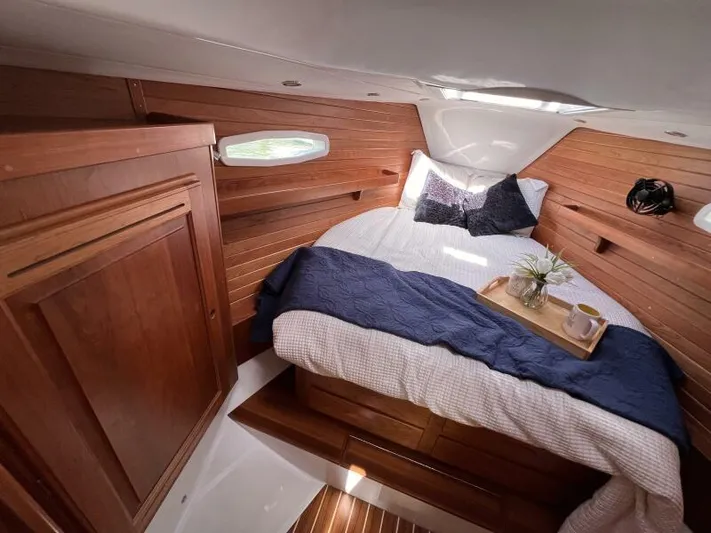 #14 Yacht Photos Pics Luxurious cabin interior of 2024 Tartan 395 yacht with cozy bed and wooden finish.