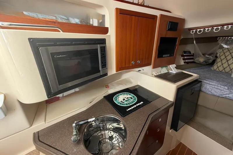  Yacht Photos Pics 2009 Grady-White Express 330 interior with kitchenette, microwave, and cozy sleeping area.