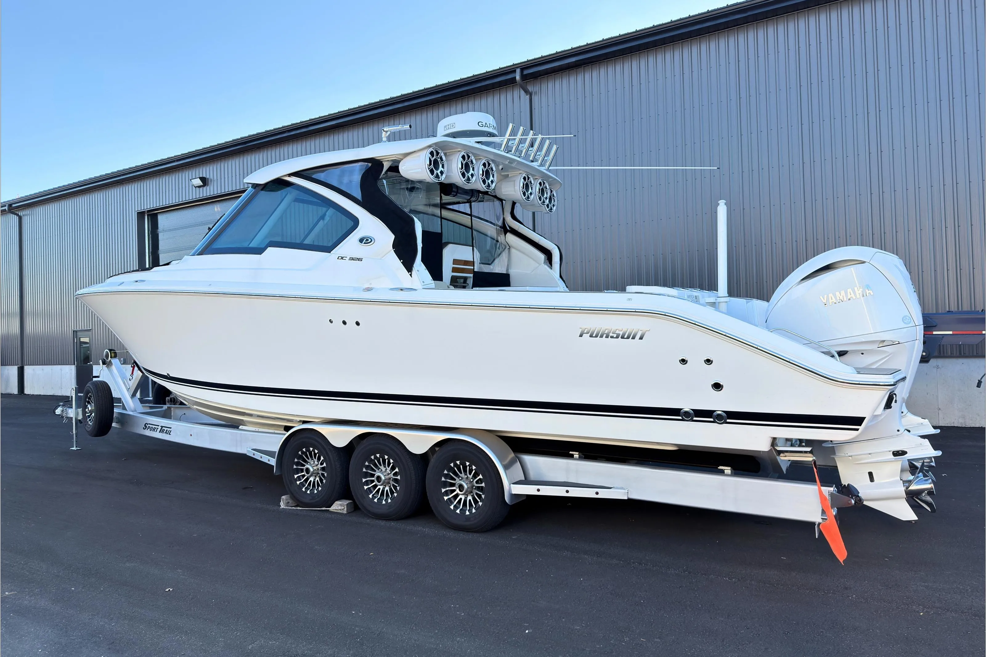 2021 Pursuit DC 326 Dual Console boat on trailer, parked outside a warehouse.