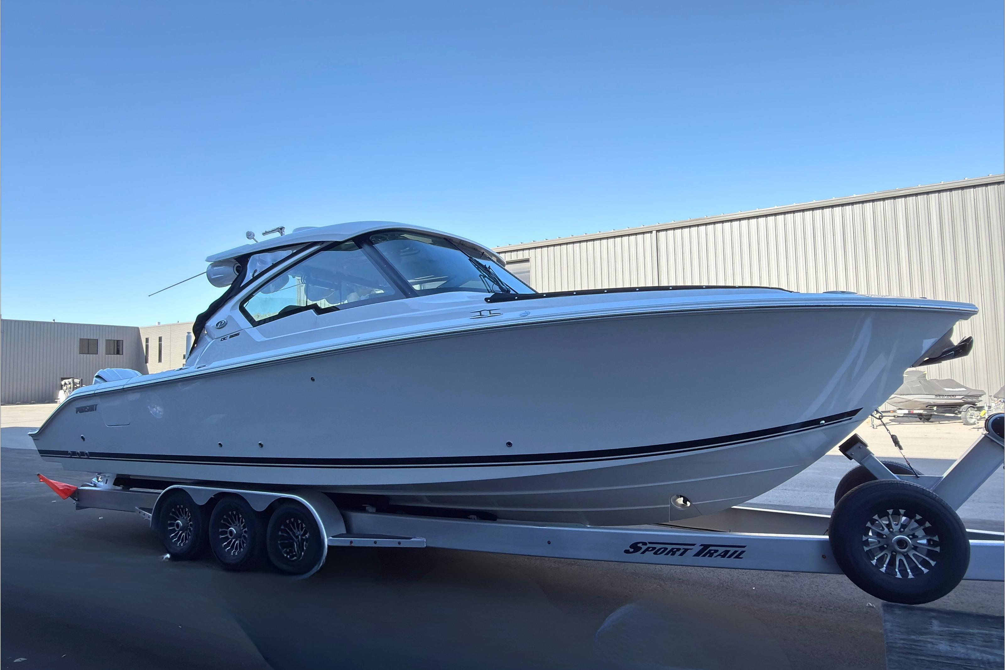2021 Pursuit DC 326 Dual Console boat on trailer, side view, outdoors.