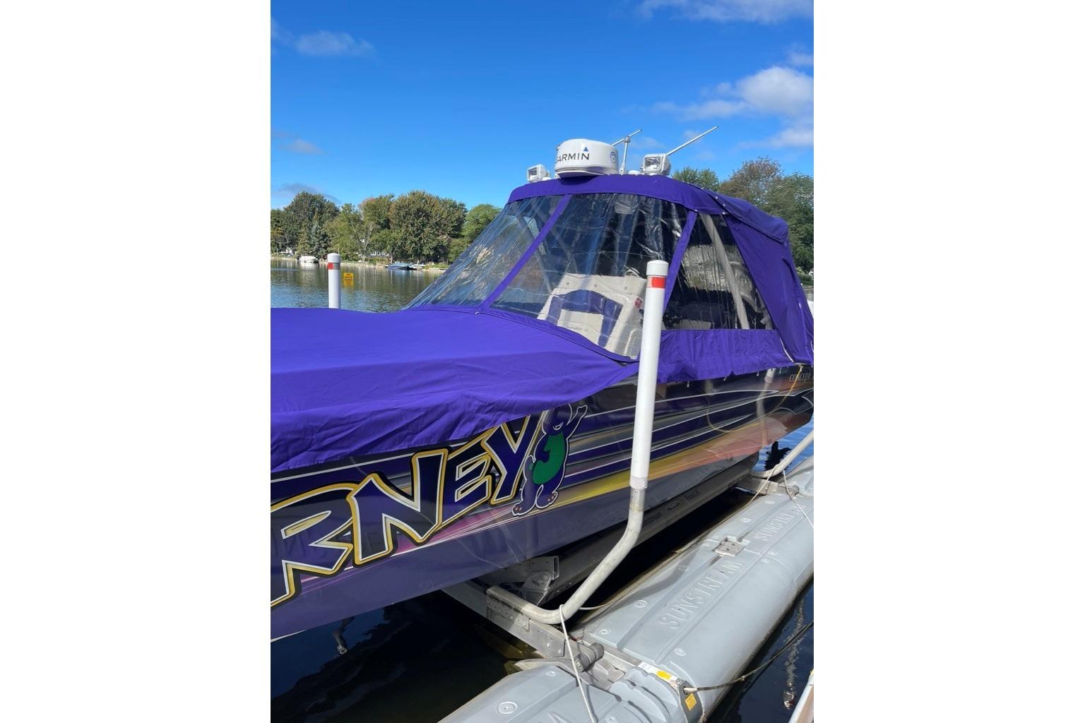 2014 Concept Boats 36CC with purple cover docked on a sunny day.