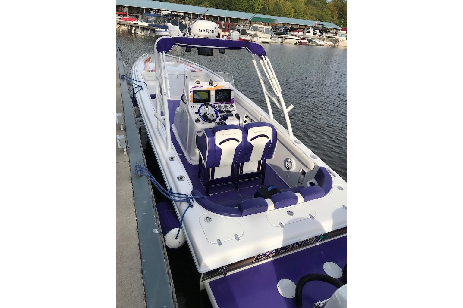 2014 Concept Boats 36CC with purple accents docked at a marina.
