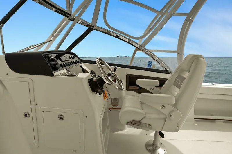 Patsy Ru Yacht Photos Pics 2016 Grady-White 285 Freedom boat cockpit with steering wheel and captain's chair, ocean view.