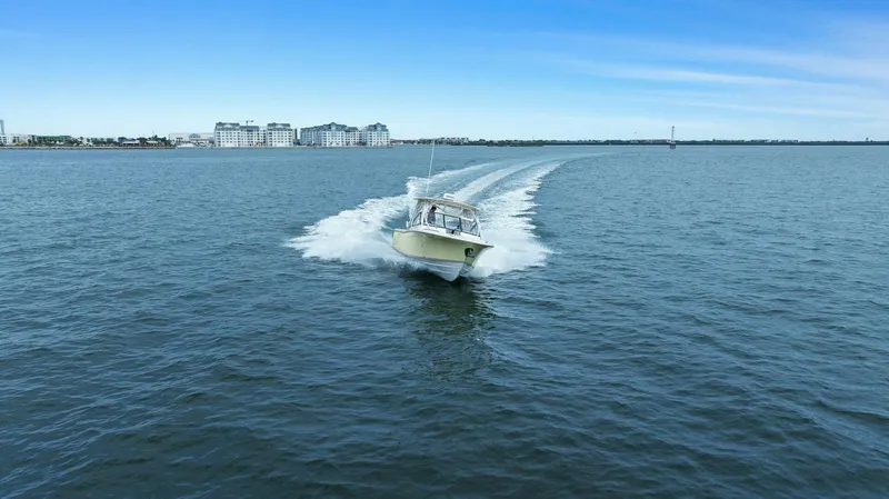 Patsy Ru Yacht Photos Pics 2016 Grady-White 285 Freedom boat cruising on open water with cityscape in background.