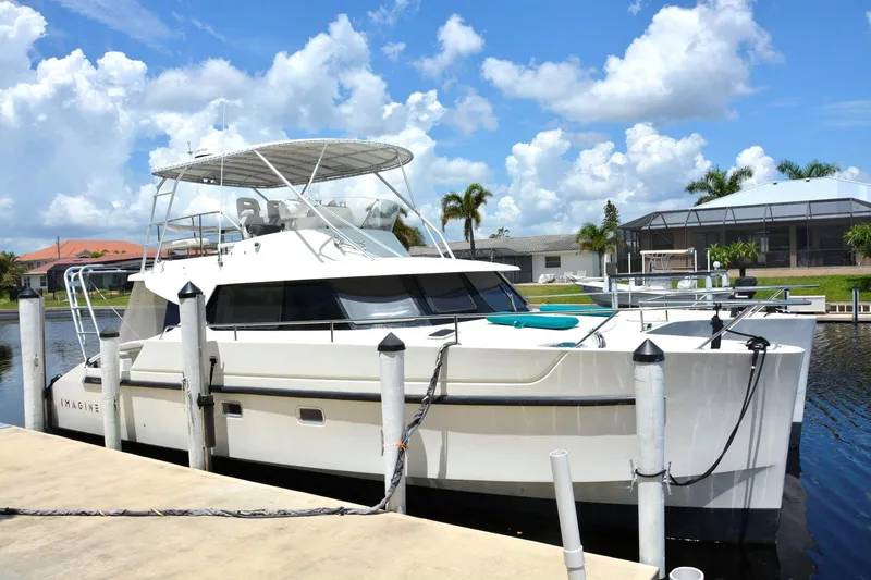 Imagine Yacht Photos Pics 2000 Fountaine Pajot Maryland 37 yacht docked by waterfront homes under blue sky.