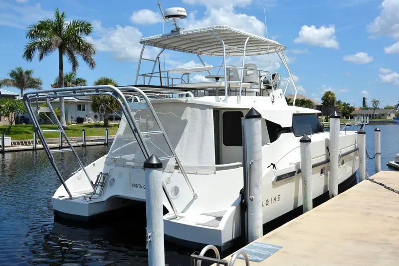 Imagine Yacht Photos Pics Fountaine Pajot Maryland 37 yacht docked, 2000 model, sunny day, palm trees in background.