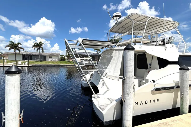 Imagine Yacht Photos Pics Fountaine Pajot Maryland 37 yacht docked by palm trees, clear sky, and calm water.