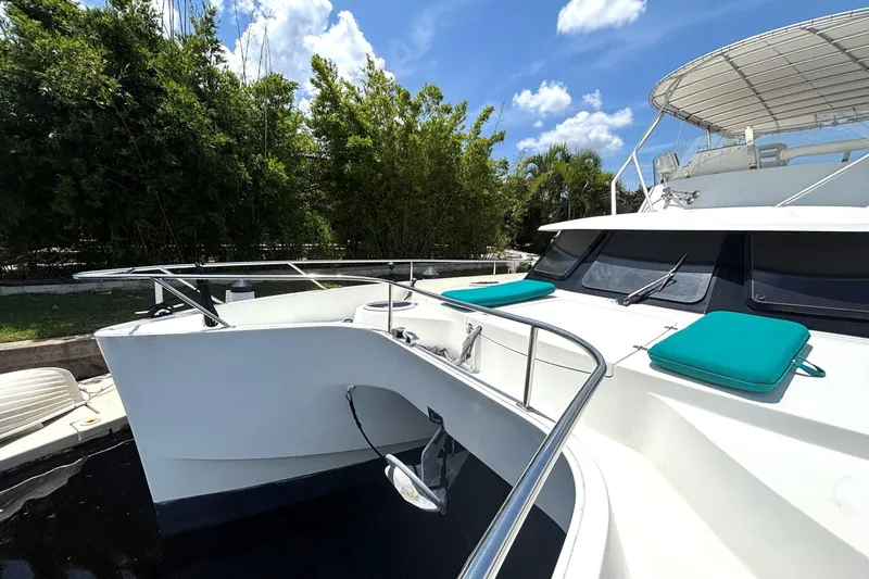 Imagine Yacht Photos Pics 2000 Fountaine Pajot Maryland 37 yacht with teal cushions, docked under a sunny sky.