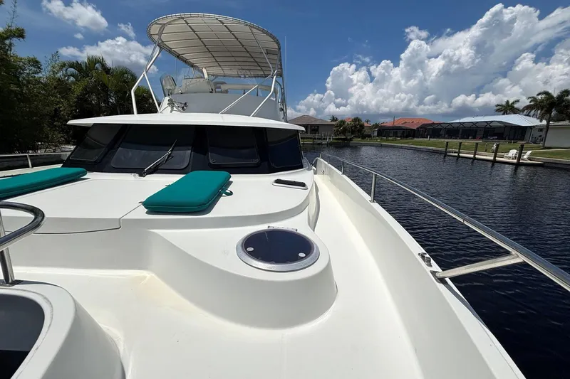 Imagine Yacht Photos Pics Fountaine Pajot Maryland 37 yacht, 2000 model, docked by a canal under a sunny sky.