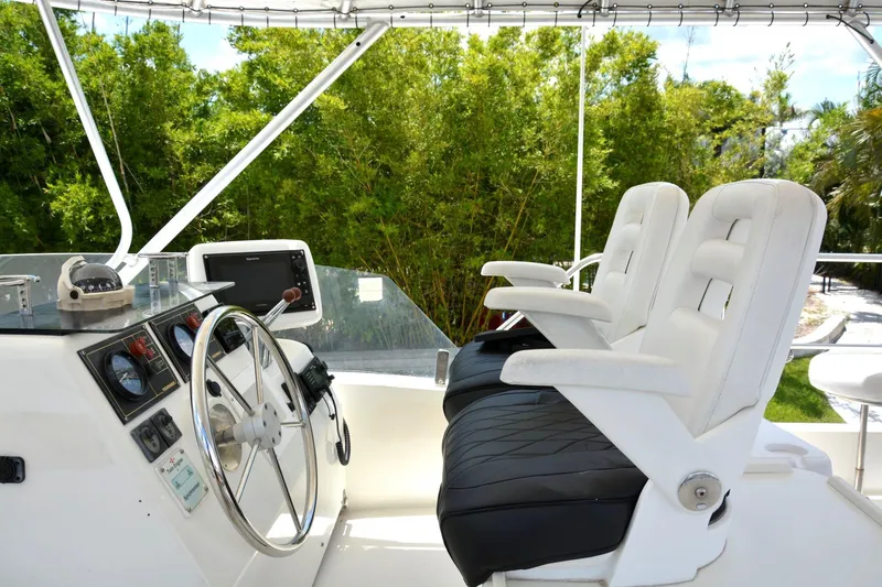 Imagine Yacht Photos Pics Helm of 2000 Fountaine Pajot Maryland 37 with dual white captain chairs and navigation equipment.