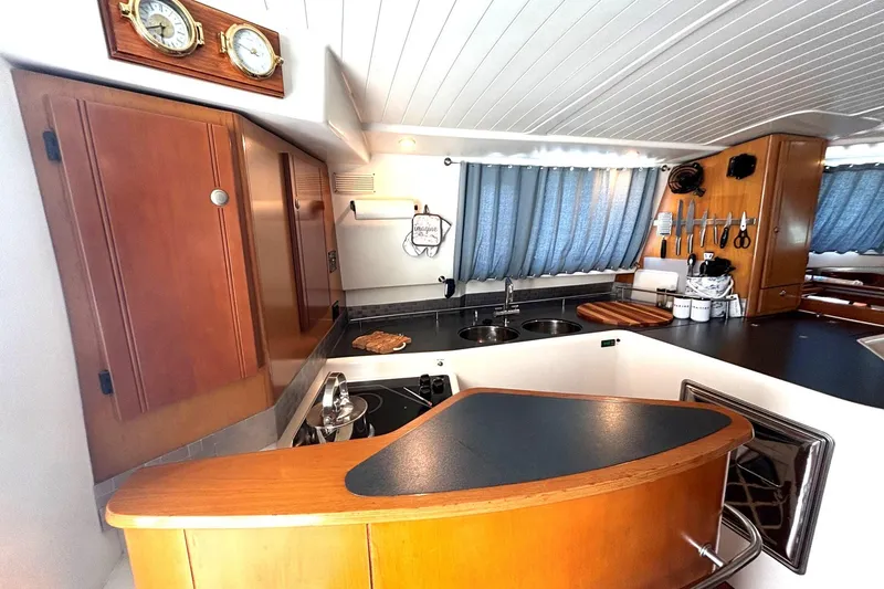 Imagine Yacht Photos Pics Interior of 2000 Fountaine Pajot Maryland 37 yacht kitchen with wooden cabinets and modern appliances.