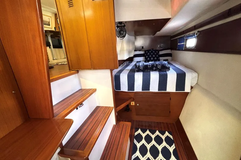 Imagine Yacht Photos Pics Cozy cabin interior of 2000 Fountaine Pajot Maryland 37 with striped bedding and wooden accents.