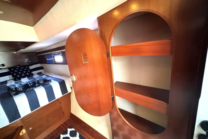 Imagine Yacht Photos Pics Cozy cabin interior of 2000 Fountaine Pajot Maryland 37 with wooden shelves and bed.