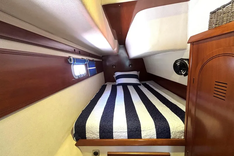 Imagine Yacht Photos Pics Cabin interior of 2000 Fountaine Pajot Maryland 37 with striped bedding and wooden accents.