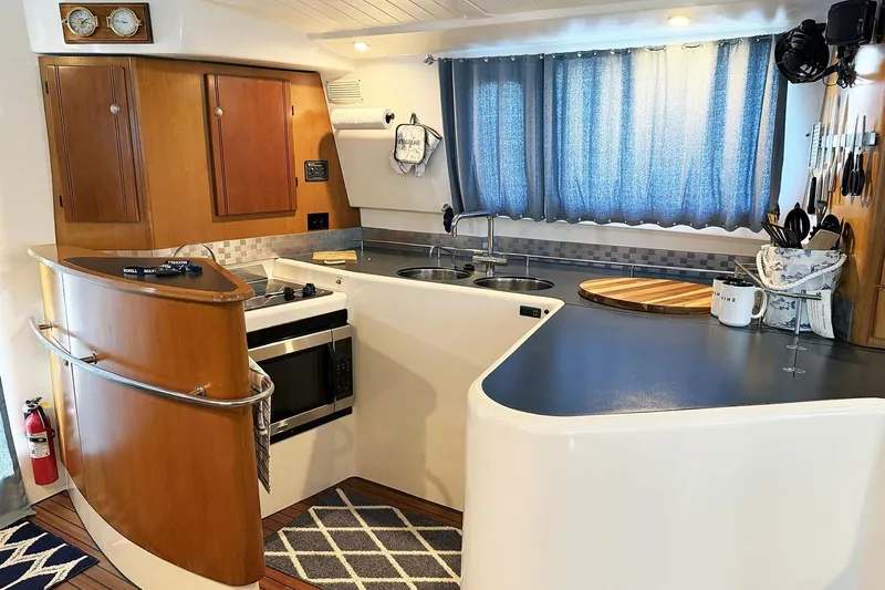 Imagine Yacht Photos Pics Modern kitchen interior of 2000 Fountaine Pajot Maryland 37 yacht, featuring wood cabinetry and appliances.