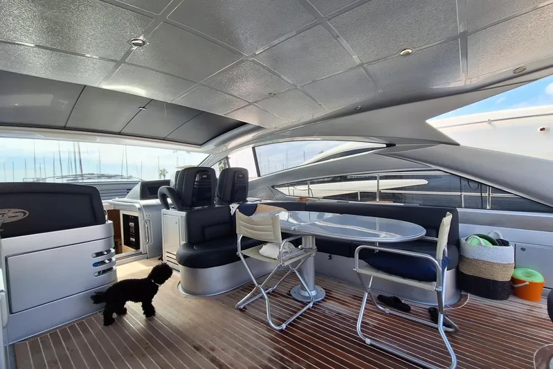 Domale Yacht Photos Pics Luxurious 2009 Pershing 56 yacht interior with seating, table, and a small dog.