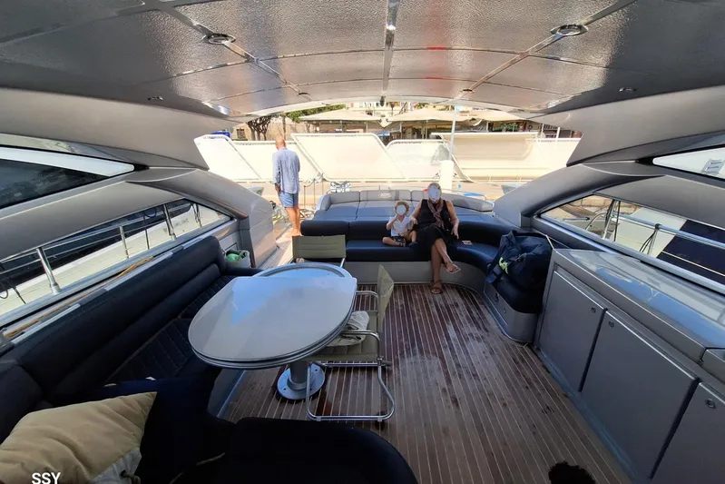 Domale Yacht Photos Pics Luxurious 2009 Pershing 56 yacht interior with seating and table, docked at marina.