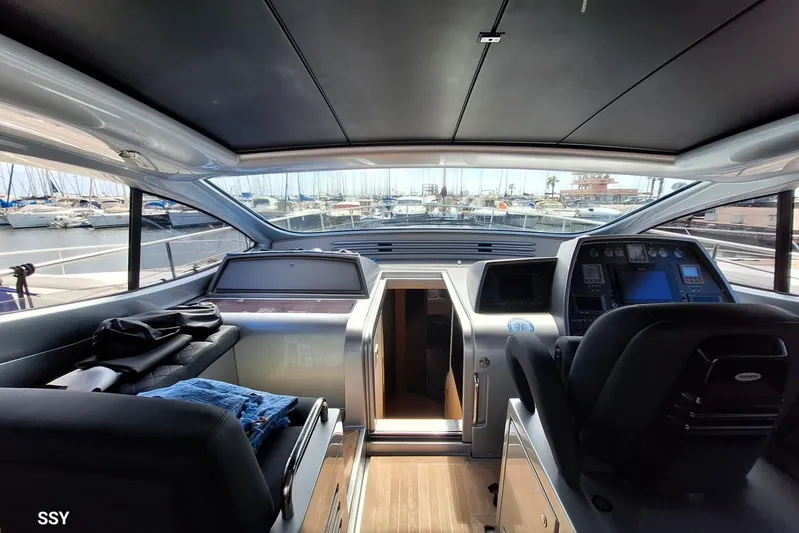 Domale Yacht Photos Pics Interior view of 2009 Pershing 56 yacht cockpit with marina backdrop.