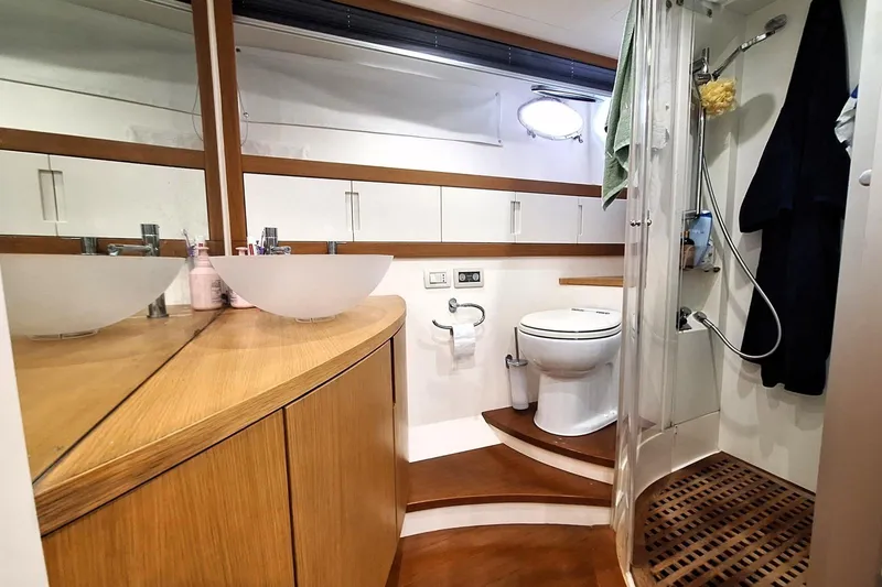 Domale Yacht Photos Pics Luxurious bathroom in 2009 Pershing 56 yacht with modern fixtures and wooden accents.
