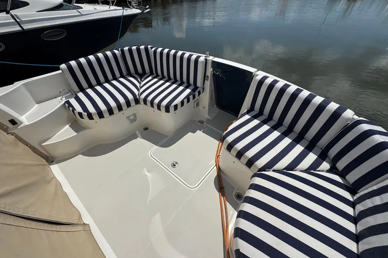 Mary Time Yacht Photos Pics 2013 Back Cove 30 boat with striped seating, docked by calm water.