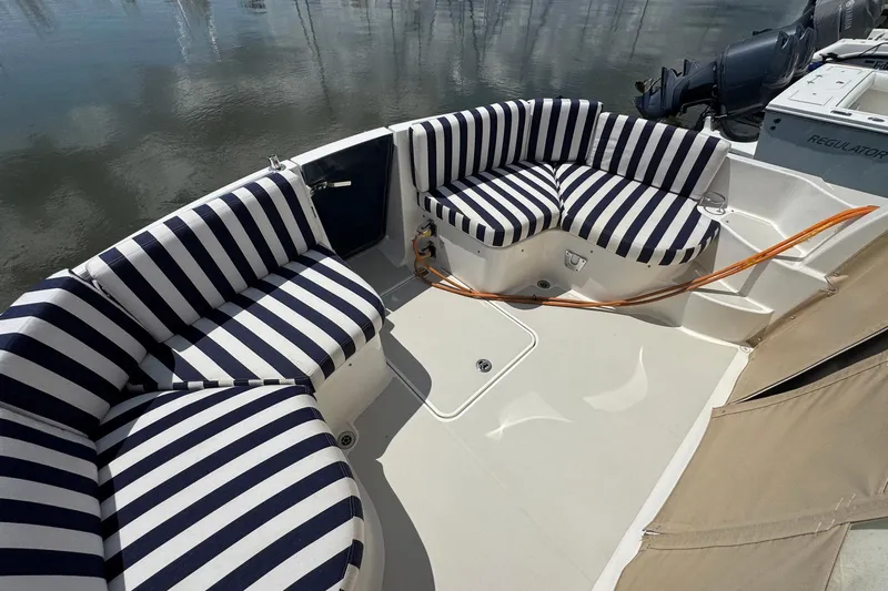 Mary Time Yacht Photos Pics 2013 Back Cove 30 boat with striped seating, docked by calm water.