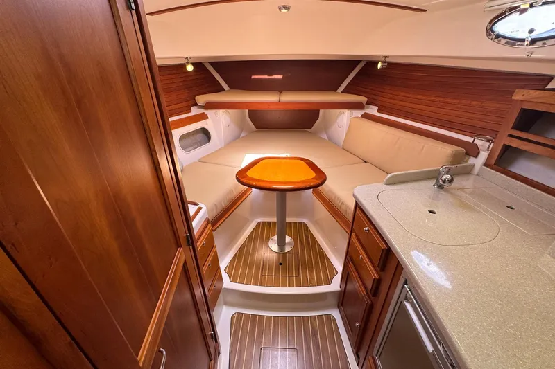 Mary Time Yacht Photos Pics 2013 Back Cove 30 interior with cozy seating, wooden accents, and compact kitchenette.