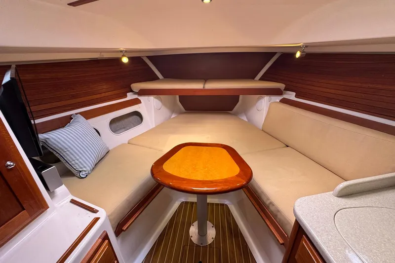 Mary Time Yacht Photos Pics 2013 Back Cove 30 interior cabin with beige seating, wooden accents, and a central table.