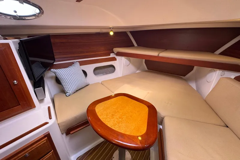 Mary Time Yacht Photos Pics 2013 Back Cove 30 interior with cozy seating, wooden accents, and a mounted TV.