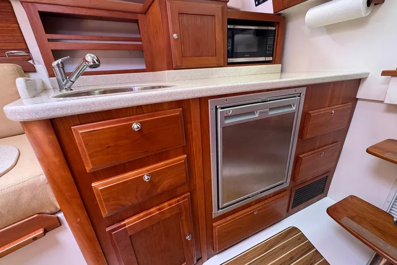 Mary Time Yacht Photos Pics 2013 Back Cove 30 yacht interior with wooden cabinetry, sink, and built-in appliances.