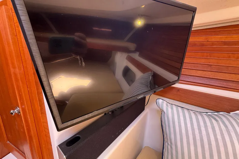 Mary Time Yacht Photos Pics Flat-screen TV in 2013 Back Cove 30 boat interior with wood paneling and striped pillow.
