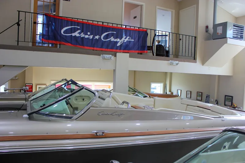  Yacht Photos Pics 2013 Chris-Craft Launch 32 boat displayed indoors with branded banner above.