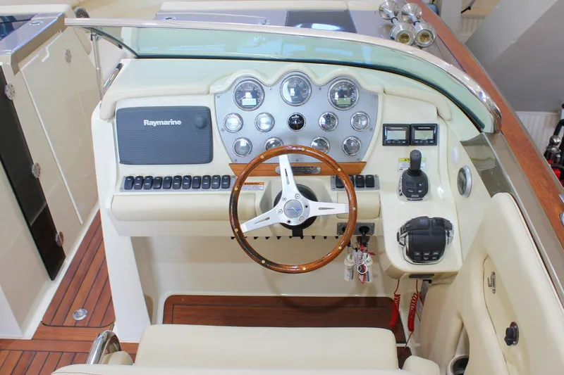  Yacht Photos Pics 2013 Chris-Craft Launch 32 dashboard with Raymarine electronics and wooden steering wheel.