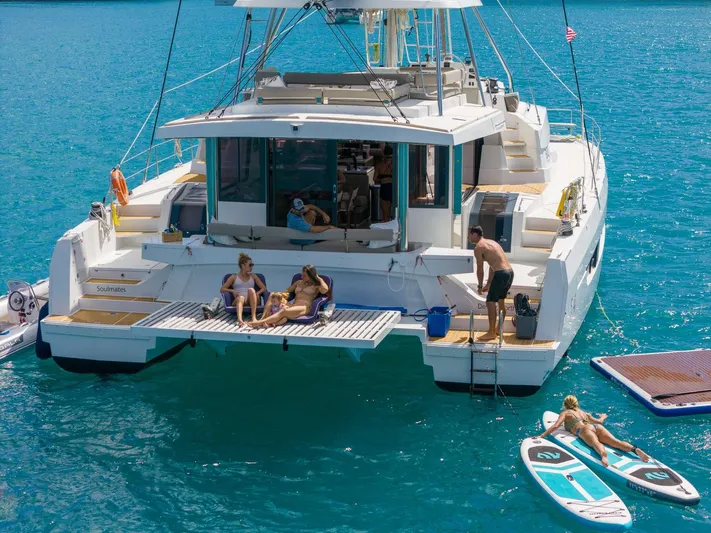  Yacht Photos Pics People relaxing on a 2023 Bali 5.4 catamaran in clear blue water.