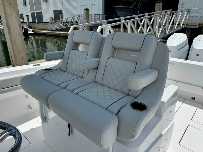  Yacht Photos Pics Luxury seating on 2025 Intrepid 345 Nomad FE boat, docked with visible outboard engines.