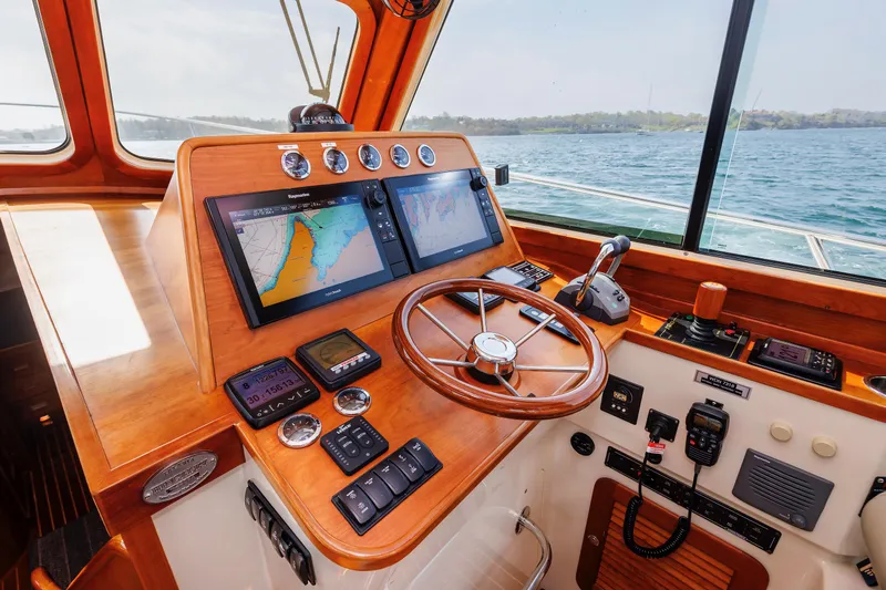 Ruckus Yacht Photos Pics Helm of 2009 Hinckley Talaria 44 MY with navigation screens and wooden steering wheel.