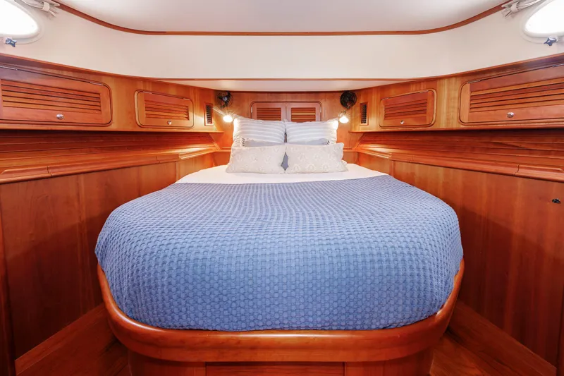 Ruckus Yacht Photos Pics Luxurious cabin interior of 2009 Hinckley Talaria 44 MY with wooden finish and cozy bedding.