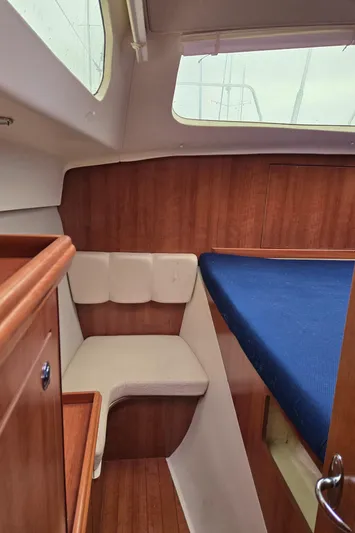14hands Yacht Photos Pics Interior of 2013 Gemini Legacy 35 sailboat with wood paneling and blue bedding.