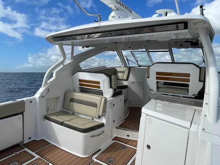 Lady B Yacht Photos Pics 2019 Pursuit 365 Dual Console boat interior with seating, wood accents, and ocean view.
